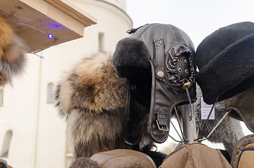 Image showing black leather beautifully sewn hats in market 