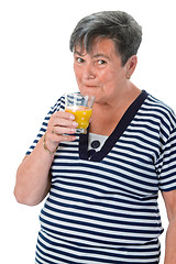 Image showing Senior woman drinking orange juice