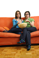 Image showing female friends eating popcorn and watching tv at home