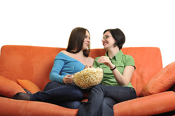 Image showing female friends eating popcorn and watching tv at home