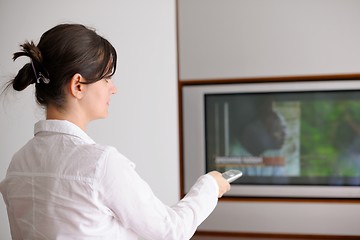 Image showing young woman watching tv at home