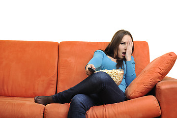 Image showing young woman eat popcorn and watching tv