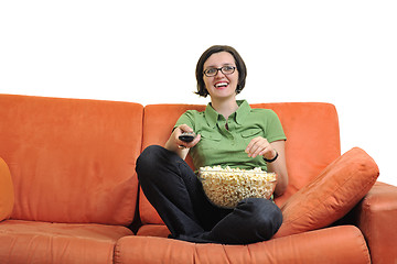 Image showing young woman eat popcorn and watching tv