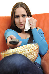 Image showing young woman eat popcorn and watching tv