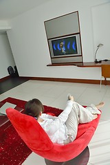 Image showing young woman watching tv at home