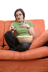 Image showing young woman eat popcorn and watching tv