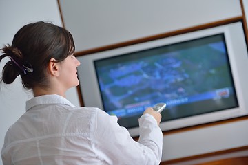 Image showing young woman watching tv at home