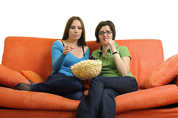 Image showing female friends eating popcorn and watching tv at home