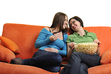 Image showing female friends eating popcorn and watching tv at home