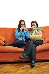 Image showing female friends eating popcorn and watching tv at home