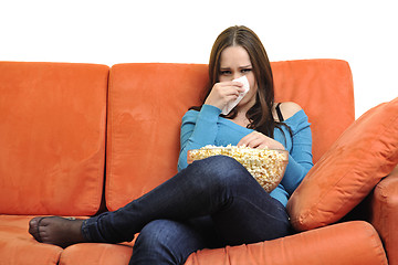 Image showing young woman eat popcorn and watching tv