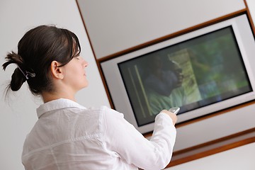 Image showing young woman watching tv at home