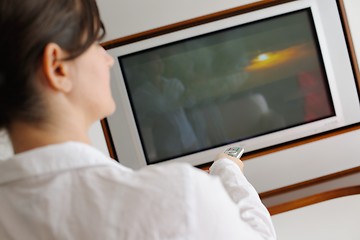 Image showing young woman watching tv at home