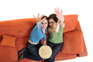 Image showing female friends eating popcorn and watching tv at home