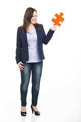 Image showing Business woman holding a puzzle piece