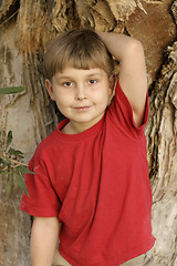 Image showing Boy leaning against a tree