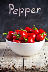 Image showing red hot peppers in bowl and blackboard 