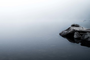Image showing Reflections of rocks in a foggy lake