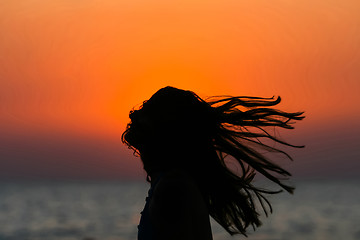 Image showing Abstract of woman tossing hair at sunset 