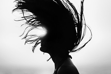 Image showing Silhouette of woman tossing hair at sunset black and white
