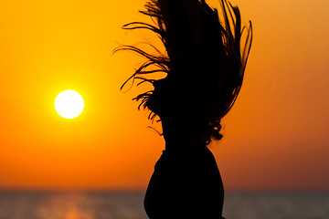 Image showing Woman tossing hair at sunset