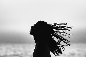 Image showing Abstract of woman tossing hair at sunset black and white