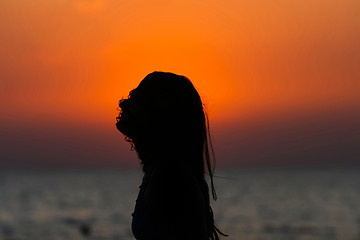 Image showing Young woman at sunset with hair on her face