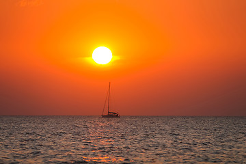 Image showing Boat sailing at sunset on open sea