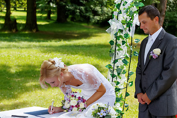 Image showing beautiful blonde smiling bride signed contract