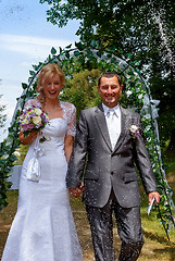 Image showing Happy just married couple under a rice rain