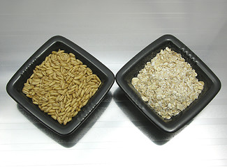 Image showing Bowls of chinaware with oat and porridge on reflecting matting