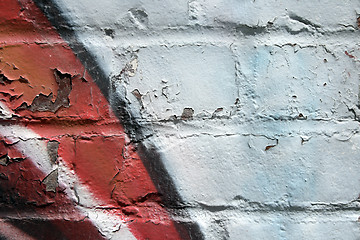 Image showing Graffiti on a peeling brick wall