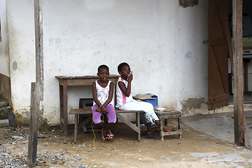 Image showing African girls sit in front of a house