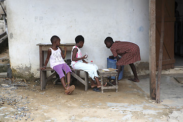 Image showing African girls sit in front of a house