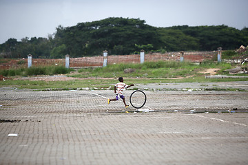 Image showing African boy plays with a tire