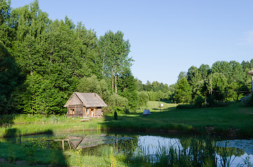 Image showing countryside with wooden bathhouse and green nature 