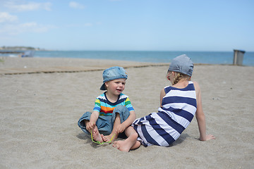 Image showing Little boy and girl sitting on the beach