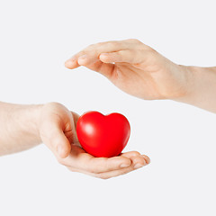 Image showing male hands with small red heart