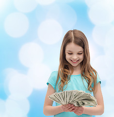 Image showing smiling little girl looking at dollar cash money