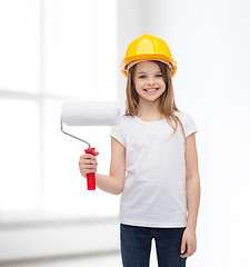 Image showing smiling little girl in helmet with paint roller