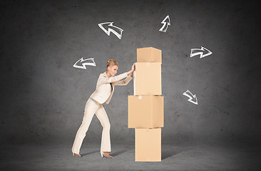 Image showing businesswoman pushing tower of cardboard boxes