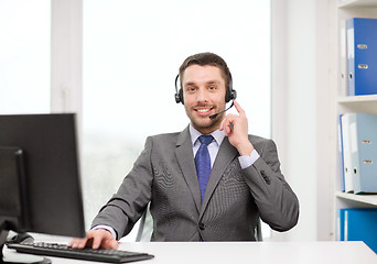 Image showing helpline operator with headphones and computer