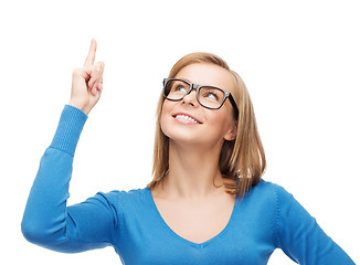 Image showing smiling woman pointing her finger up