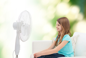 Image showing smiling little girl with big fan at home