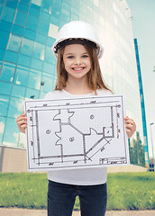 Image showing smiling little girl in helmet showing blueprint