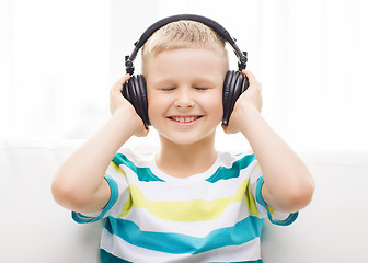 Image showing smiling little boy with headphones at home