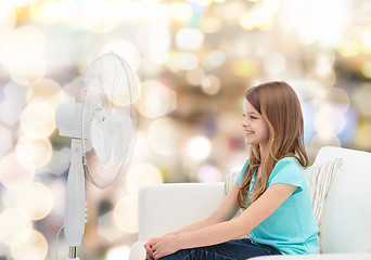 Image showing smiling little girl with big fan at home