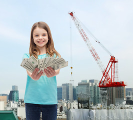 Image showing smiling little girl giving dollar cash money