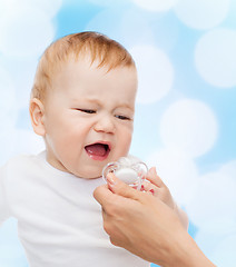 Image showing crying baby with dummy