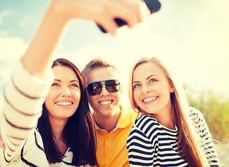 Image showing friends taking picture with smartphone camera